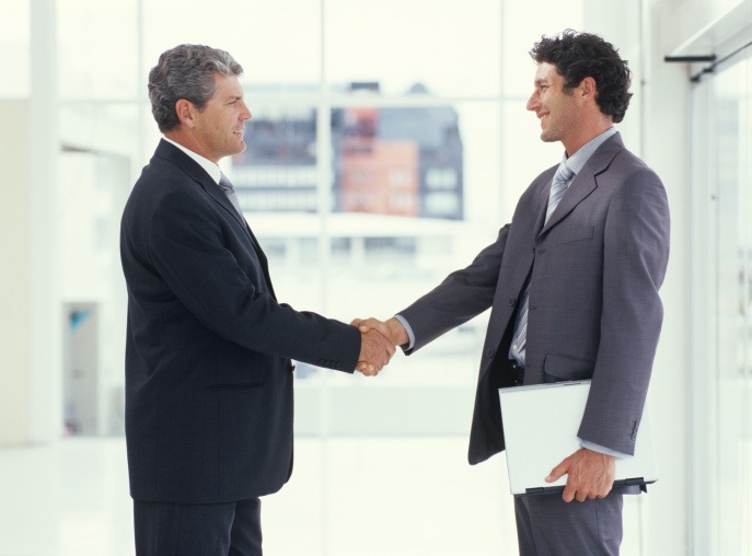 Two businessmen shaking hands, side view