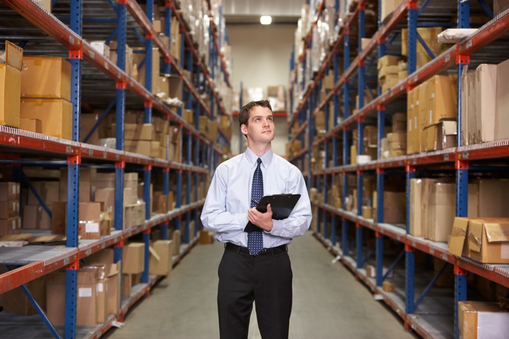 Manager In Warehouse With Clipboard